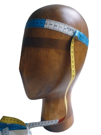 a wooden mannequin with a measuring tape on it
